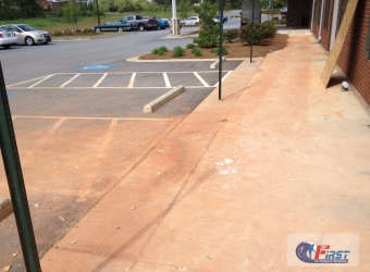 Clean commercial parking lot and concrete sidewalk after pressure washing
